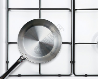 金属餐厅勺子上炉香料的空钢煎锅白色图片