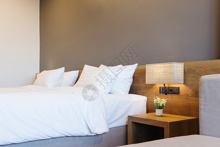 白色的墙室内旅馆卧装饰的白色枕头加灯在床上装饰紧贴白枕头明亮的背景图片