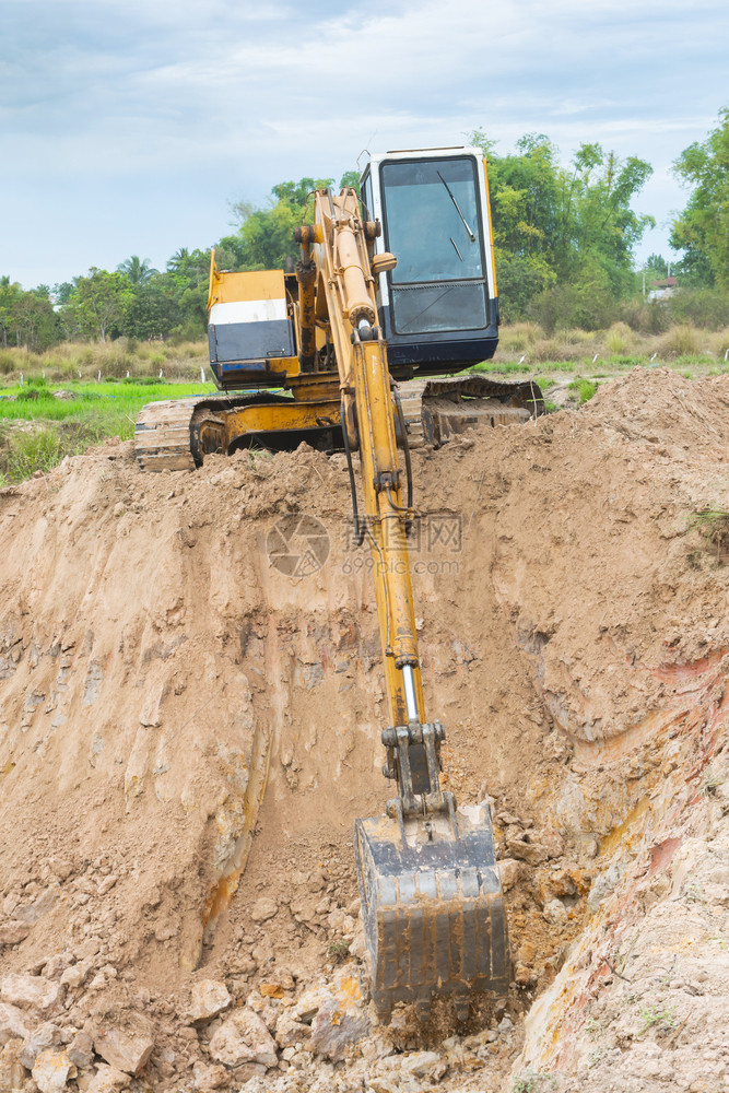 金属铲拆除黄色挖掘机在施工现场进行土方程图片