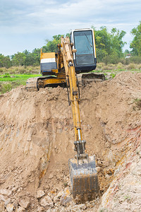 金属铲拆除黄色挖掘机在施工现场进行土方程图片