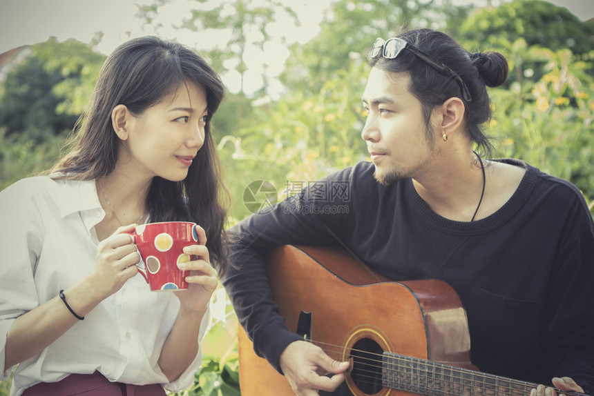 女年青的亚洲男女玩吉他和快乐感弹成人泰国图片
