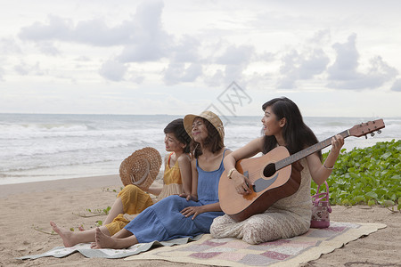 乐趣更年轻青的女朋友在海滨玩吉他暑假上享受快乐情绪夏天图片