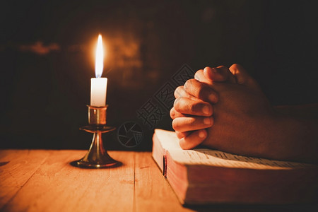 叉黑色的人祈祷圣经在灯蜡烛中有选择的焦点宗教宗教的高清图片素材