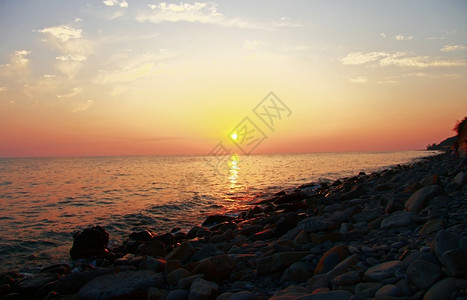 日落在黑海和夏季滩上令水太阳图片