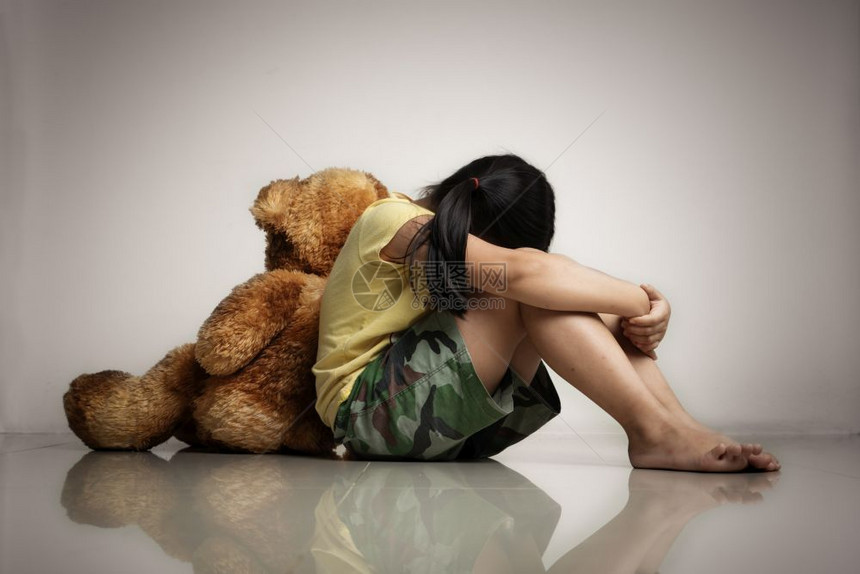 天有泰迪熊的小女孩坐在空房间里的地板上精神和沮丧的家庭概念后视欺负图片