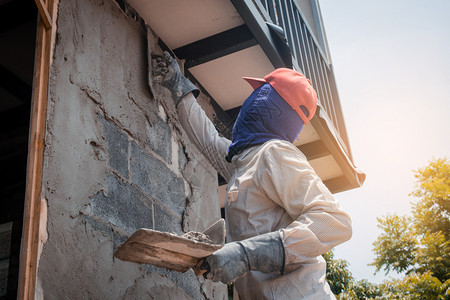建筑工人使用水泥石膏在建筑墙上打石膏磨职业建造总体高清图片素材