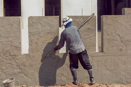 建造筑工人使用水泥石膏在建筑墙上打石膏真实的内部油灰高清图片素材