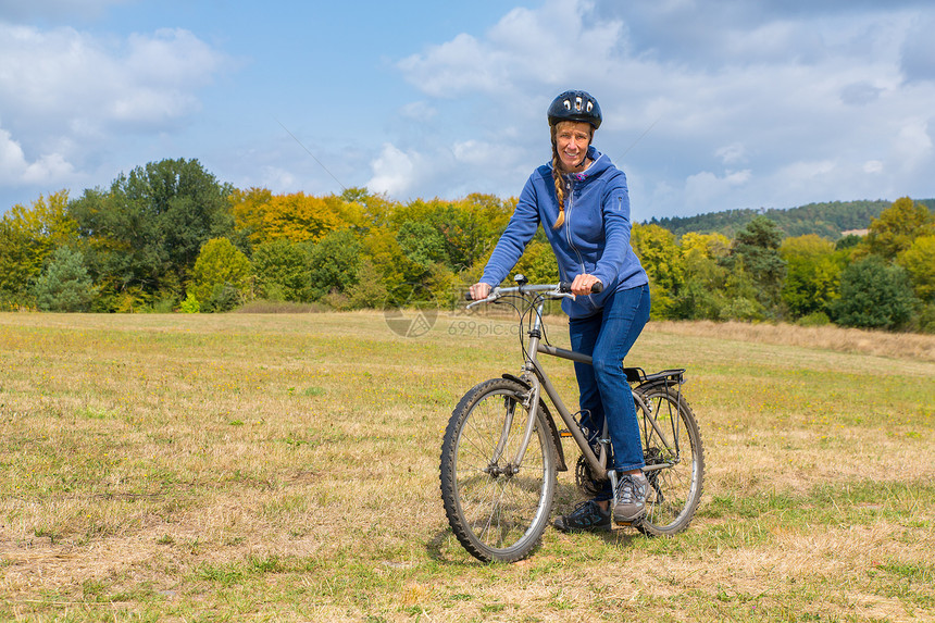 闲暇自然景观中骑行车的荷兰女山地骑自行车运动的旅图片