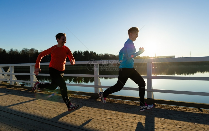 日出时有两个女人一起在桥上奔跑活动训练春天图片
