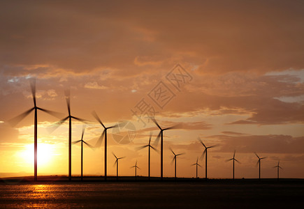 旋转日落时发电的风力涡轮机休眠白色的风电场图片