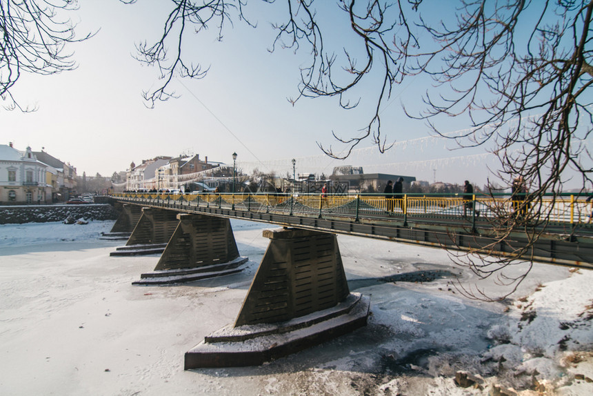 建筑学河老的Uzhgorod城市中心带冰雪的乌日哥罗德人行桥图片
