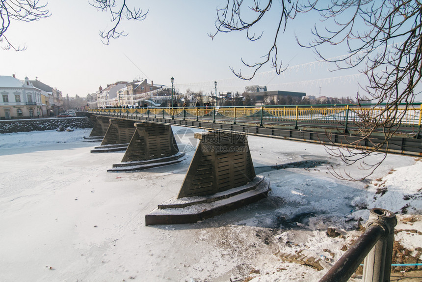 树风景优美Uzhgorod城市中心带冰雪的乌日哥罗德人行桥图片