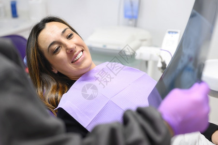 牙医手拿病人的牙齿X光片图片