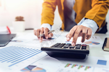 使用计算器和笔记本电脑分析财务会计的办公桌商业女人最佳预算报告图片