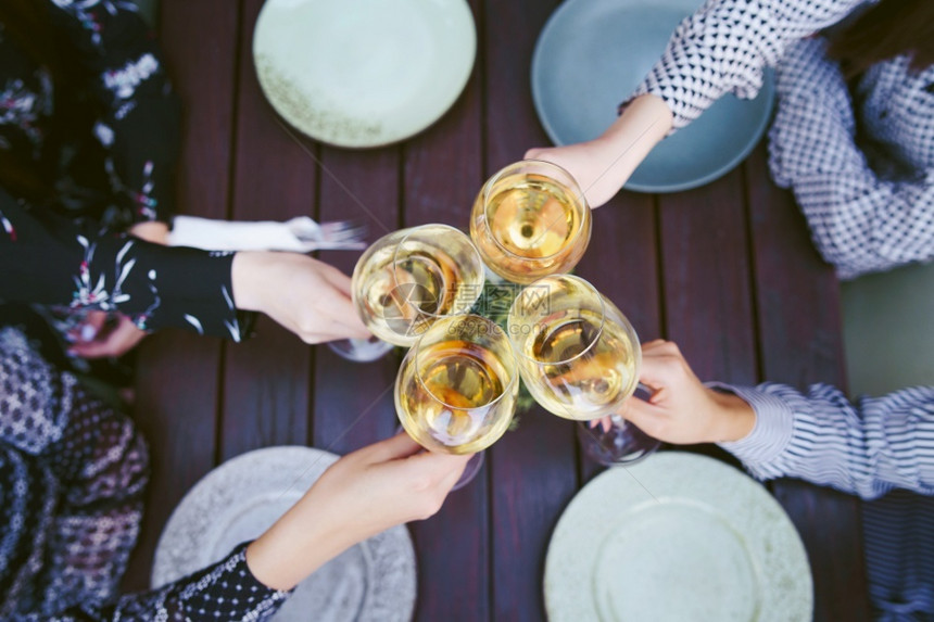 花园白色的友谊紧贴杯子上白葡萄酒在妇女手中庆祝酒图片