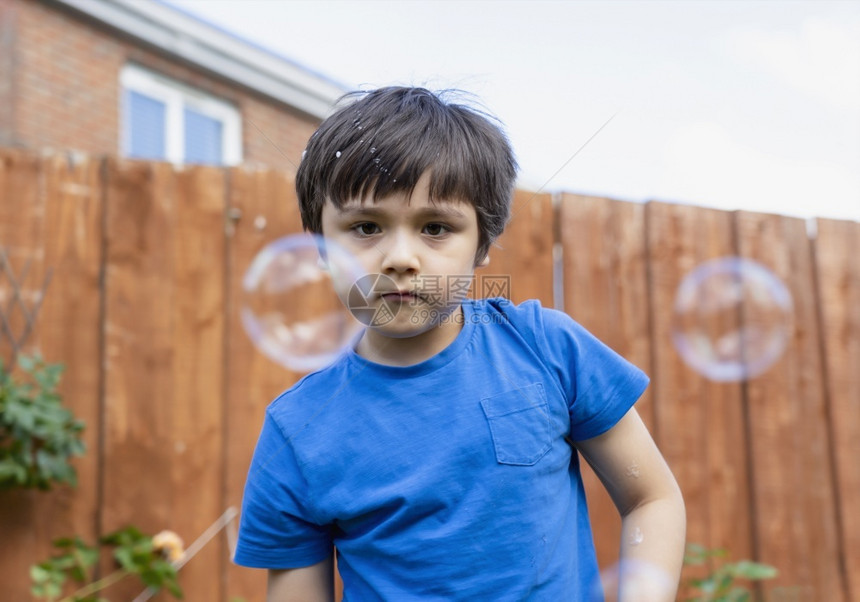 亚洲人气泡有选择焦点儿童在花园玩肥皂泡活跃的儿童男孩在阳光明日暑夏户外玩阳儿童概念有选择的焦点儿童在花园里玩肥皂泡快乐的图片