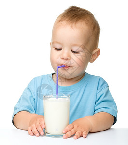 手举牌子小男孩人类青年可爱的小男孩坐在桌边子上用稻草喝牛奶在白上面被孤立保持背景