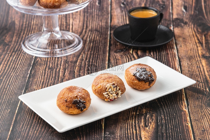 油炸Bombolone或bomboloni是意大利填满甜圈和零食的意大利品德国甜圈克拉芬或贝林机装满果酱和巧克力狂欢美食图片