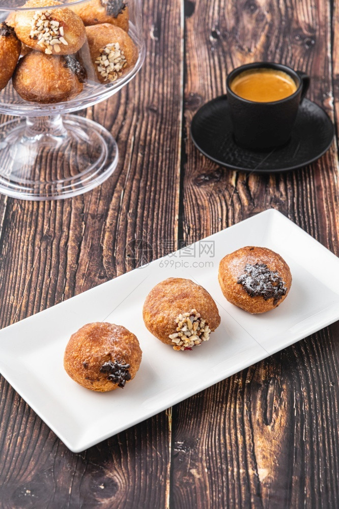 Bombolone或bomboloni是意大利填满甜圈和零食的意大利品德国甜圈克拉芬或贝林机装满果酱和巧克力饼子油炸可口图片