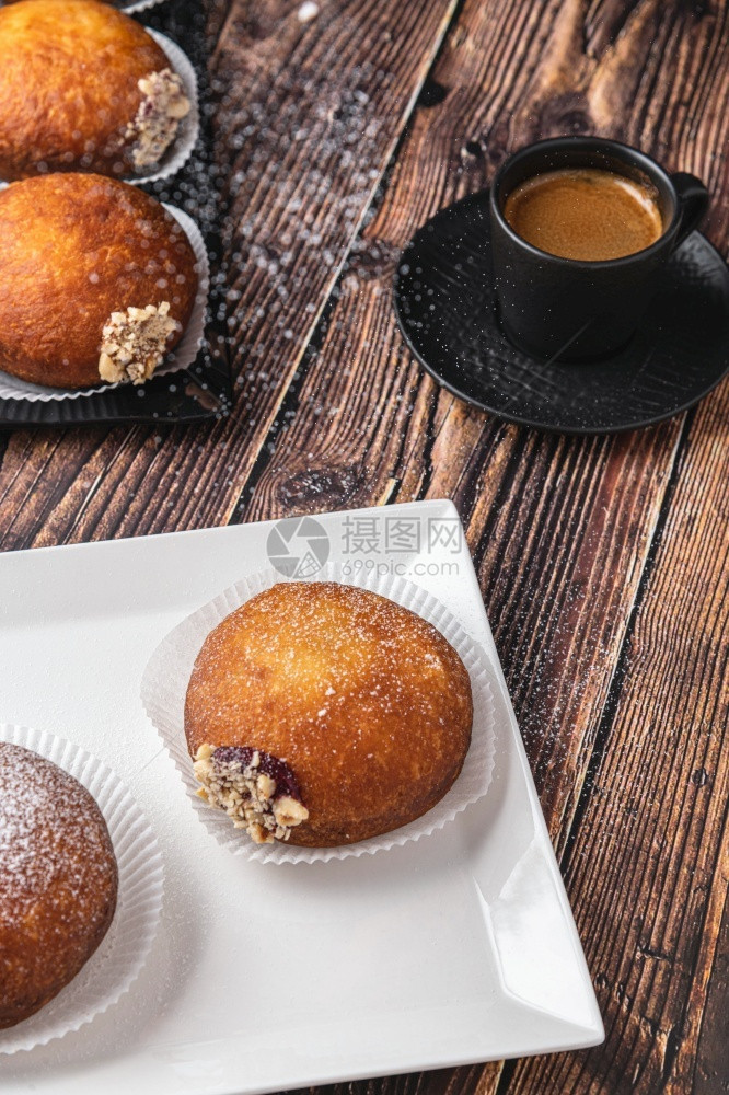 早餐Bombolone或bomboloni是意大利填满甜圈和零食的意大利品德国甜圈克拉芬或贝林机装满果酱和巧克力不良奶油图片