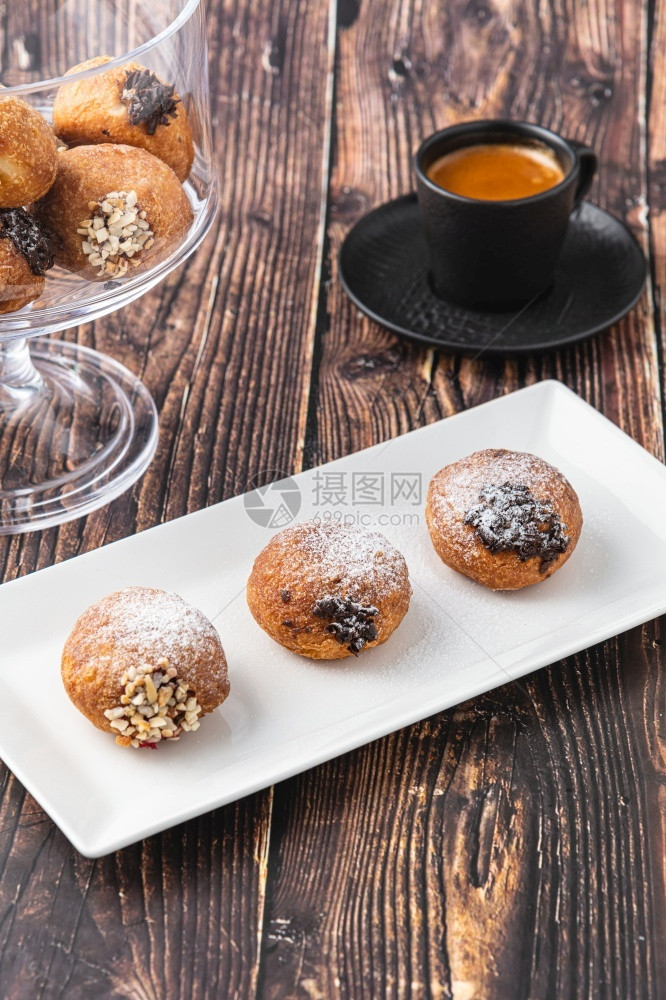 甜的Bombolone或bomboloni是意大利填满甜圈和零食的意大利品德国甜圈克拉芬或贝林机装满果酱和巧克力填充德语图片