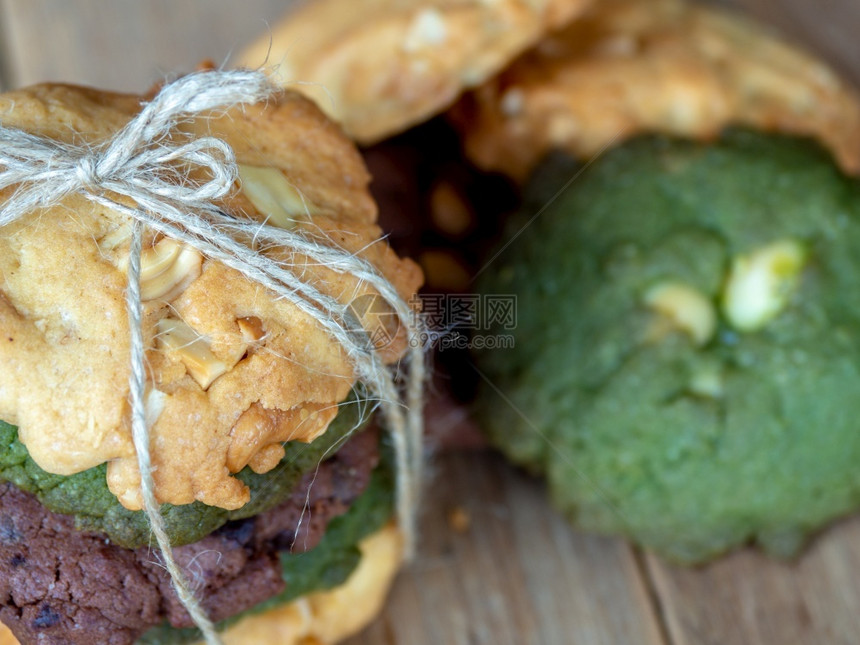 小吃季节雨多色曲奇彩饼干包括花生酱绿茶饼干和巧克力薯片曲奇饼由木板上的交替颜色覆盖图片