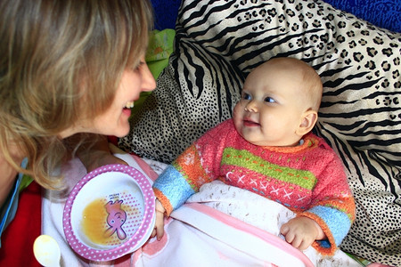 孩子们照顾幼小婴儿用童勺子喂养幼小婴儿微笑幸福图片