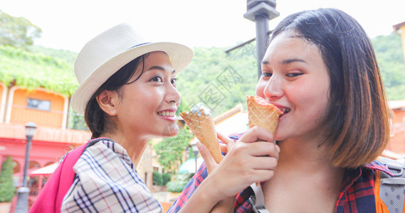 美丽的女在暑假时持有和吃冰淇淋微笑甜点奶油图片