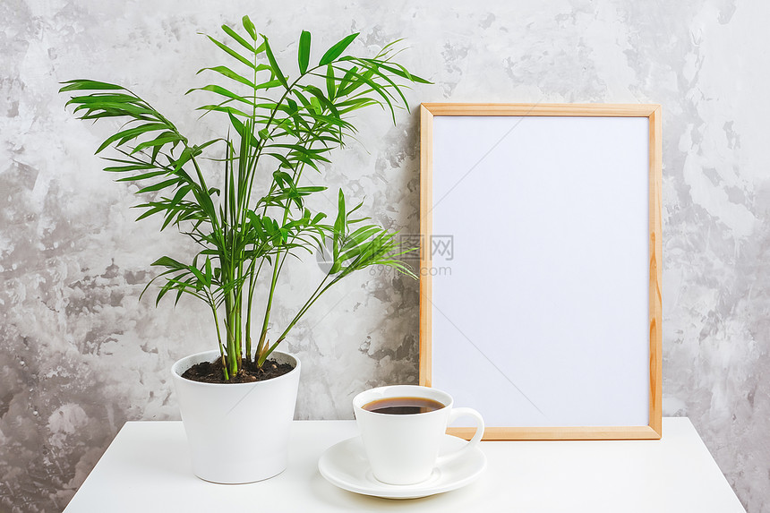 房间干净的木制带有白色空卡咖啡杯和绿色异国情调棕榈花的木制垂直框架在灰色混凝土墙背景上的桌子为您设计模板文本木制垂直框架与白色空图片