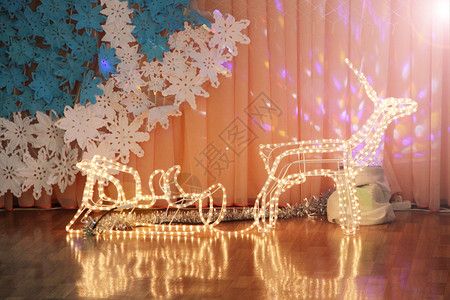 平底雪橇由花环制成的童话鹿与雪橇节日大厅的圣诞装饰品节和新年冬季日灯花环玩具除夕快乐新年和圣诞节日灯大厅的圣诞装饰品仙女美丽的明亮背景