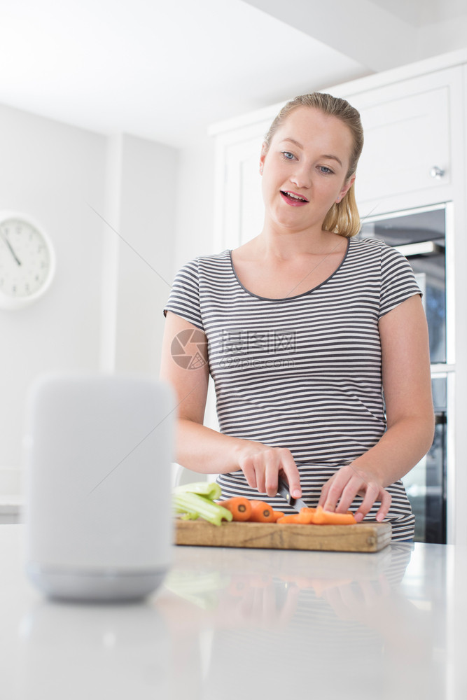 白种人在家庭询问数字助理时准备食物的妇女问题二十多岁艾图片