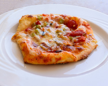 在照片中一小块披萨配着西红柿芝士辣椒洋葱和香料食物美国人送达图片