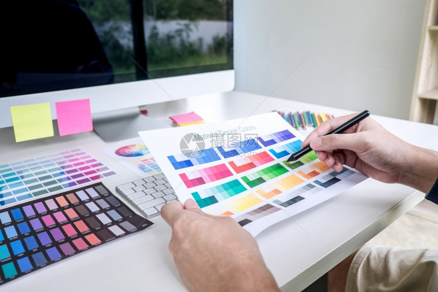 从事色选择和颜观察工作的男创造图形设计师利用工作场所带有具和附件的图形平板软制作工具及附在有工作具和附件的作场所使用图形平板丰富图片