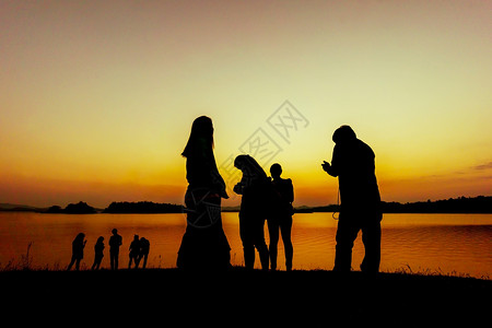 日落时靠近水边的一群人轮盘上热带常设湖图片