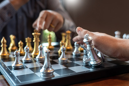 战略商人为业竞争和团队工作概念而将象棋游戏移动起来赢战斗图片
