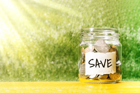 会计省钱在玻璃罐里存硬币用来节省金钱的融概念储蓄瓶子图片