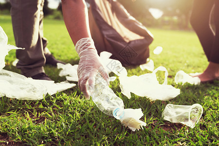 地球将垃圾塑料瓶装在黑袋中的自愿者人数处理污染图片