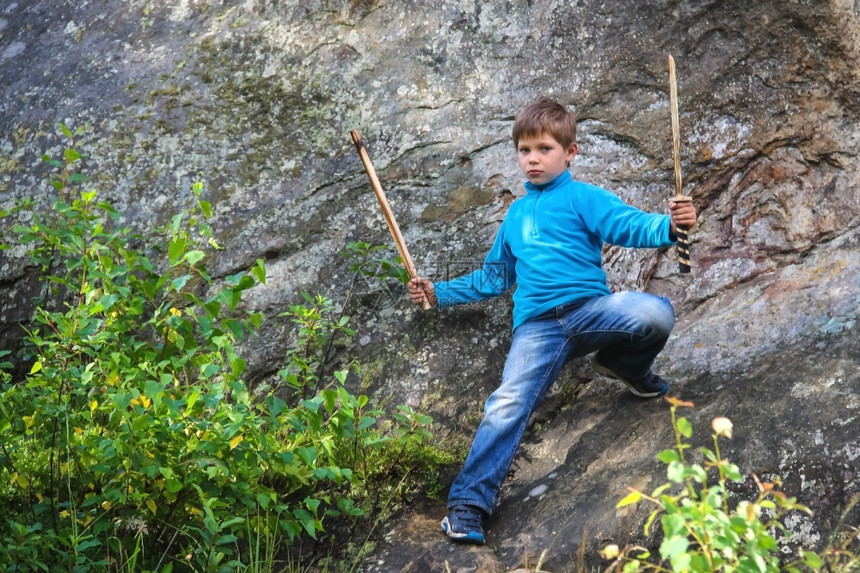 严重的孩子用木在石头上制的娱乐自然图片