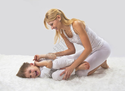 男生母亲和儿子睡前做瑜伽锻炼水平的图片