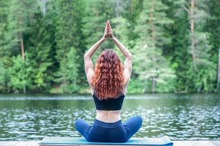 接露珠女孩闲暇在美丽的湖泊码头上青年瑜伽女孩以露珠作瑜伽默念这是健康生活和自然平衡的概念象征体操背景