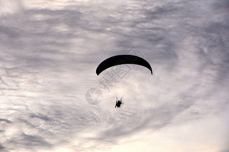 暮一个人在空中滑翔着的伞上飞行于云彩黑白背景翅膀黄昏图片