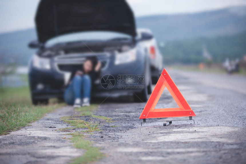 分解司机常设坐在地板上亚洲妇女坐在车撞坏的附近公路上有一辆汽车的红色三角形图片