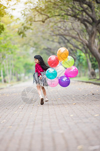 幸福孩子们假期快乐的女孩们在公园度假节日微笑带着多彩的气球跑来去夏天高清图片素材