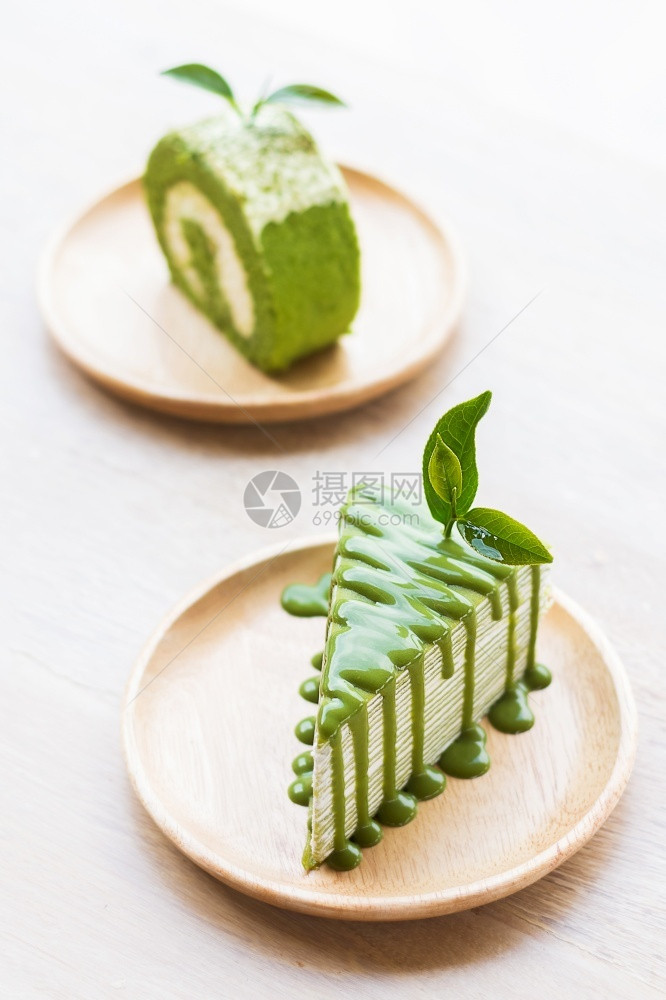 木制的自关闭盘上的绿色茶叶卷蛋糕浅深的田地关注茶叶闭绿卷饼白色的图片