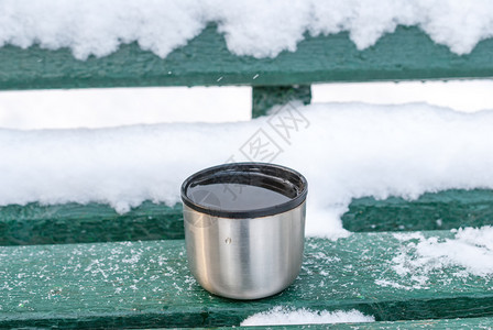 木头金属杯和热饮在雪盖的长椅上明亮食物白雪皑皑高清图片素材