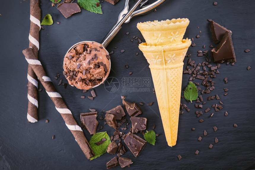 冷冻凉爽的巧克力冰淇淋加鲜果棒甜圈和巧克力在黑板上专心在勺子里的冰淇淋锥体图片
