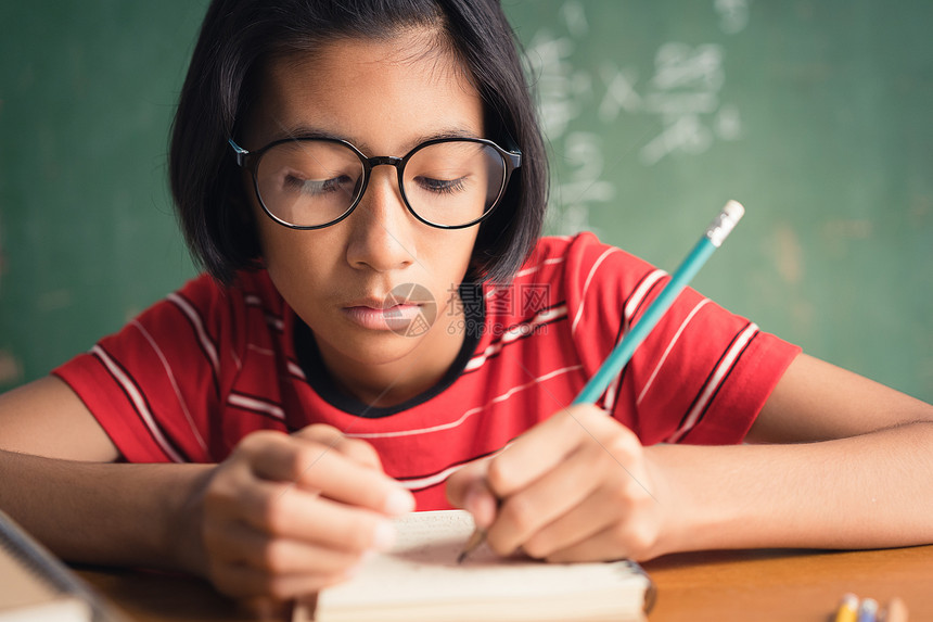 带眼镜的亚裔女孩在课堂笔记里录着她的教育概念书女亚洲人图片