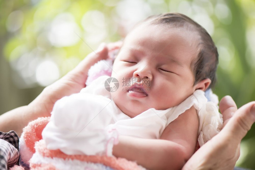 新生儿在母亲的手中睡觉有选择地关注她的眼睛家庭概念白色的可选择爱图片