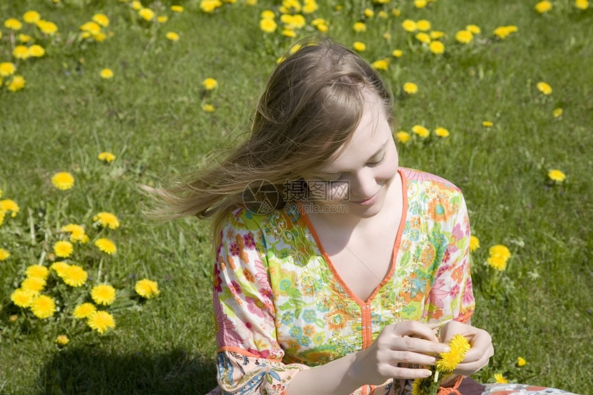自由金发带黄花的年轻妇女自然图片