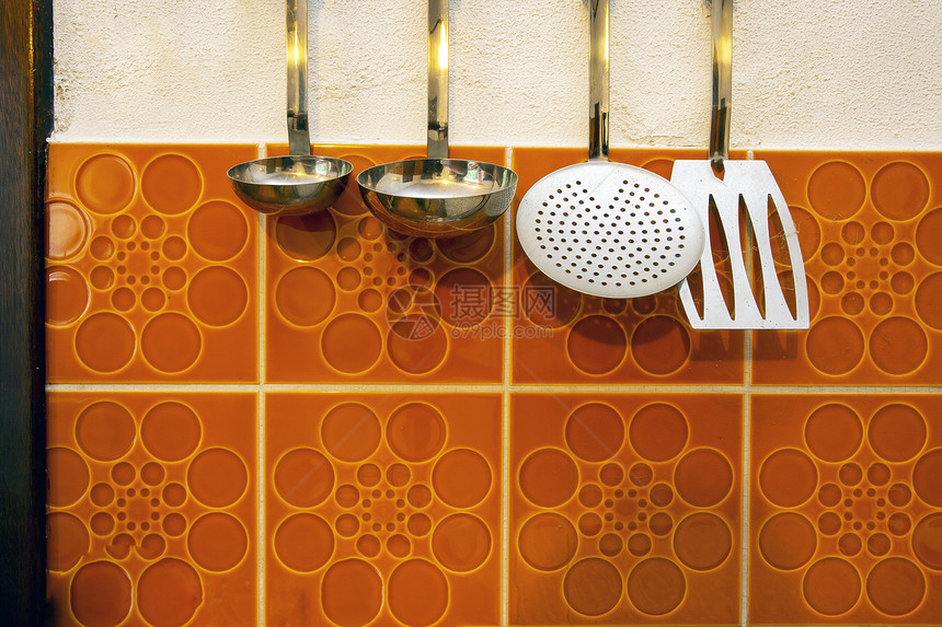 干净的Retro厨房工具挂在古老的橘子瓷砖墙背景特端雷罗厨房工具挂在古老的橙子壁背景上家目的图片